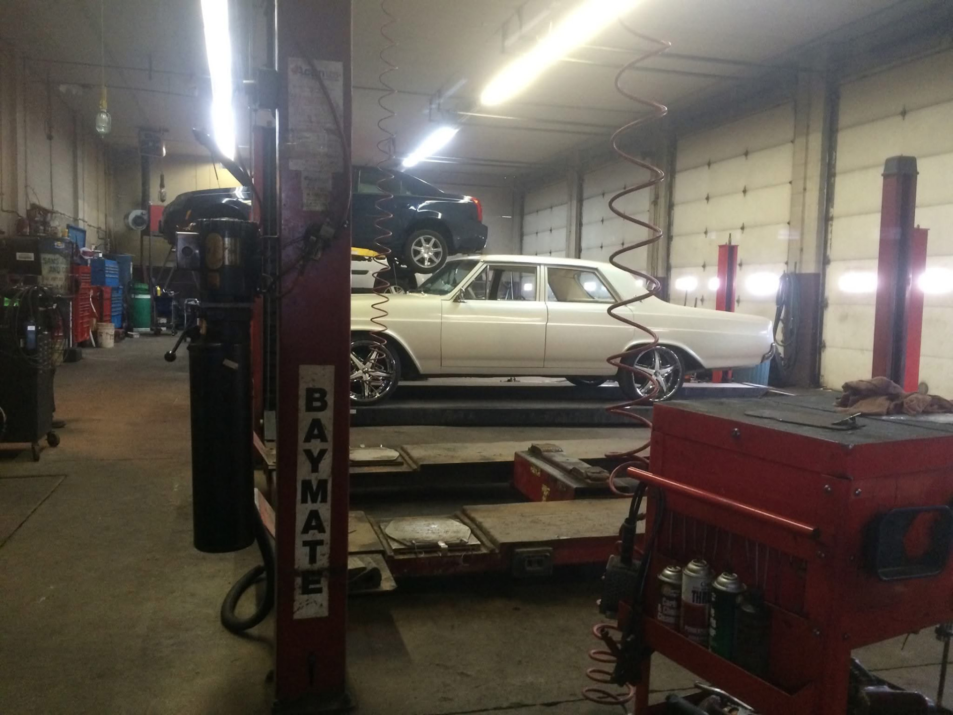 Vehicles on lifts inside the Sam's Auto by CUBI service bays